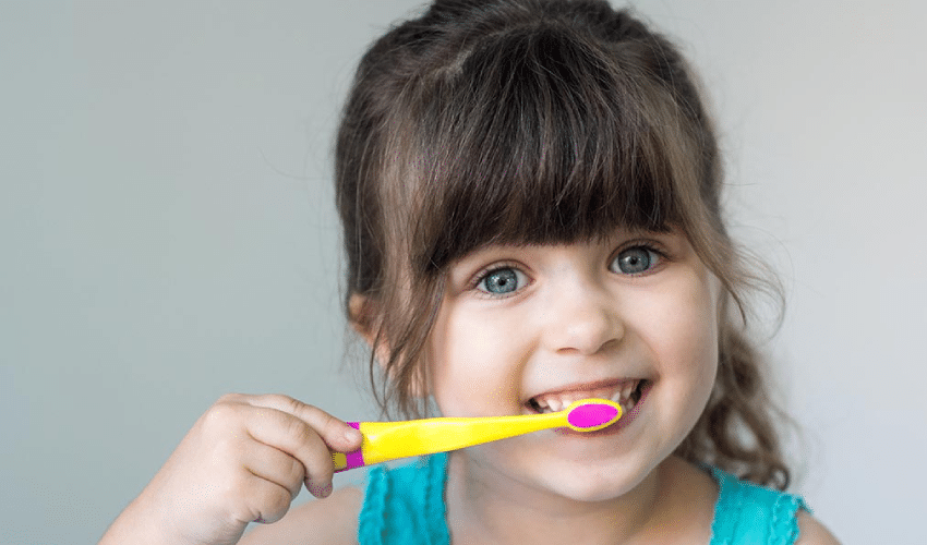 Young child brushing her teeth.